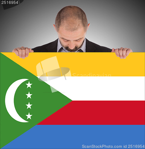 Image of Smiling businessman holding a big card or flag