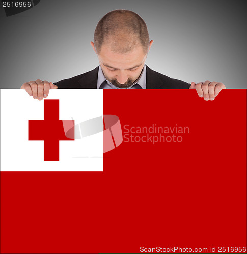 Image of Smiling businessman holding a big card or flag