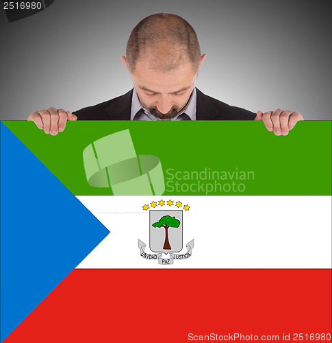 Image of Smiling businessman holding a big card or flag