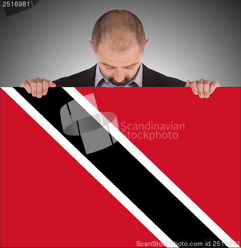 Image of Smiling businessman holding a big card or flag