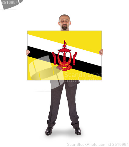 Image of Smiling businessman holding a big card or flag