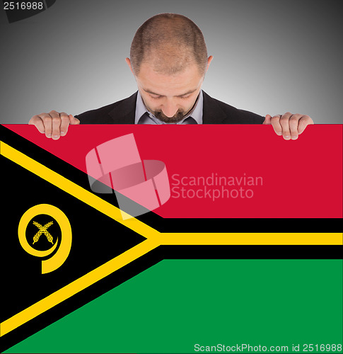 Image of Smiling businessman holding a big card or flag