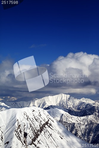 Image of Winter snowy sunlit mountains and sky with clouds