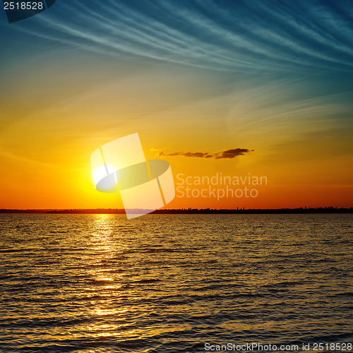 Image of summer orange sunset over darken sea