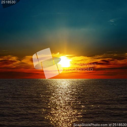 Image of red dramatic sunset over darken sea