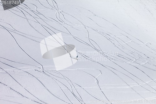 Image of Snowboarder downhill on off piste slope with newly-fallen snow