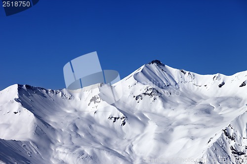 Image of Off-piste snowy slope and blue clear sky