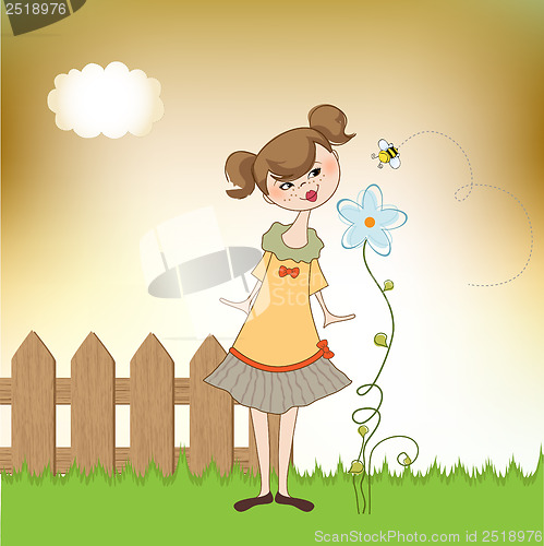 Image of small young lady who smells a flower