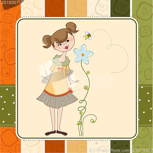 Image of small young lady who smells a flower