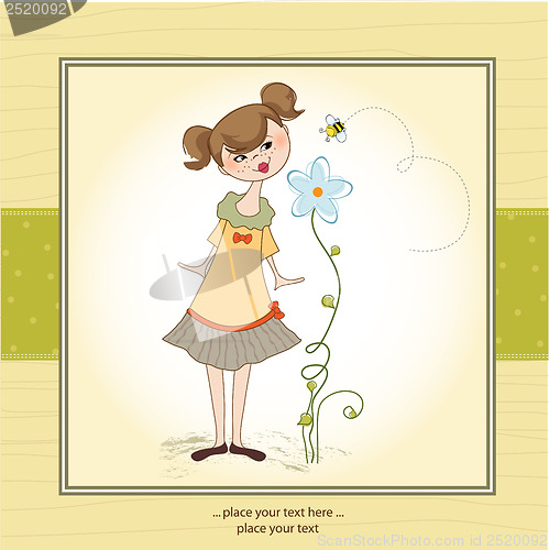 Image of small young lady who smells a flower