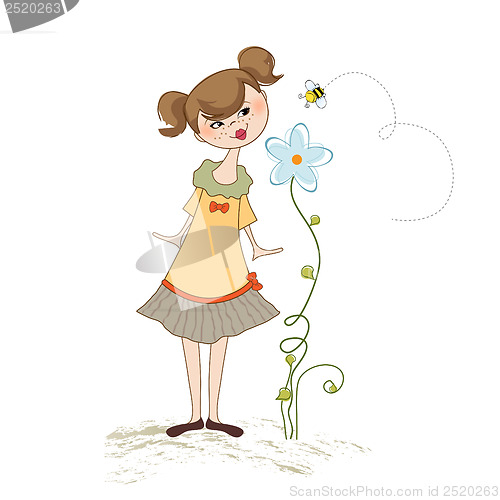 Image of small young lady who smells a flower