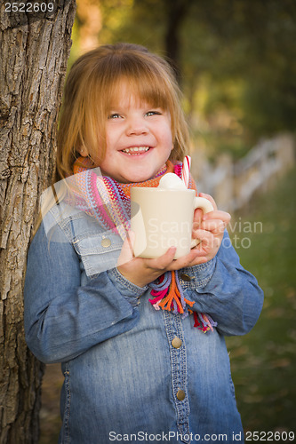 Image of Cute Young Girl Holding Cocoa Mug with Marsh Mallows Outside