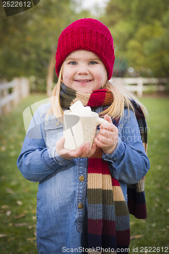 Image of Cute Young Girl Holding Cocoa Mug with Marsh Mallows Outside