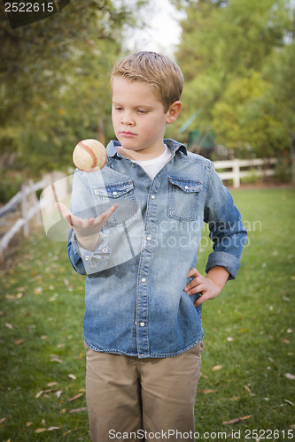 Image of Handsome Young Boy Tossing Up Baseball in the Park