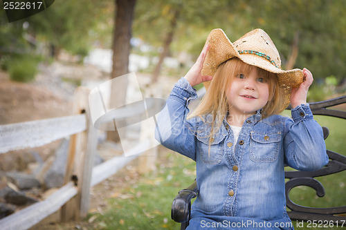 Image of Cute Young Girl Wearing Cowboy Hat Posing for Portrait Outside