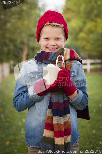 Image of Young Boy in Warm Clothing Holding Hot Cocoa Mug Outside