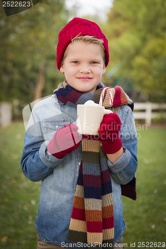 Image of Young Boy in Warm Clothing Holding Hot Cocoa Mug Outside