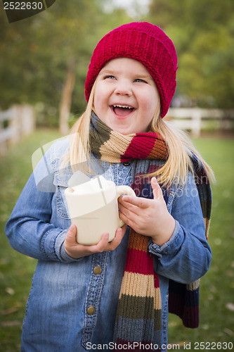 Image of Cute Young Girl Holding Cocoa Mug with Marsh Mallows Outside