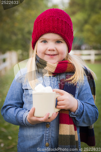 Image of Cute Young Girl Holding Cocoa Mug with Marsh Mallows Outside