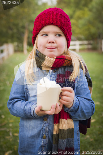 Image of Cute Young Girl Holding Cocoa Mug with Marsh Mallows Outside