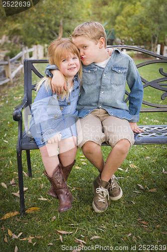 Image of Happy Young Brother and Sister Sitting Together Outside