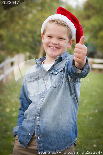 Image of Young Boy Wearing Holiday Clothing Giving a Thumbs Up Outside