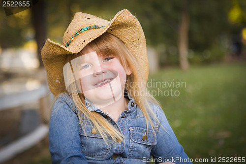 Image of Cute Young Girl Wearing Cowboy Hat Posing for Portrait Outside