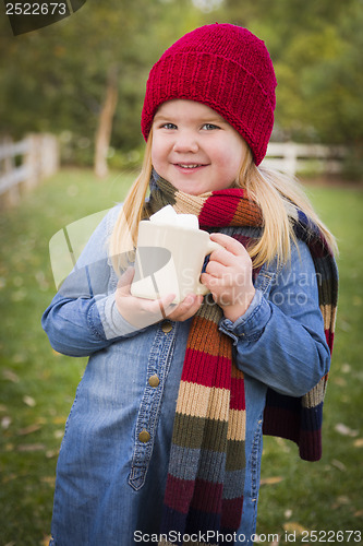 Image of Cute Young Girl Holding Cocoa Mug with Marsh Mallows Outside