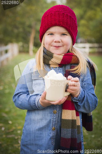 Image of Cute Young Girl Holding Cocoa Mug with Marsh Mallows Outside