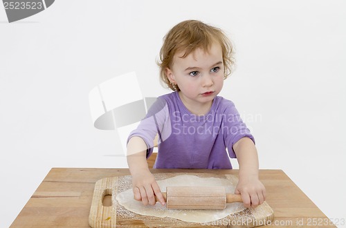 Image of child rolling out dough