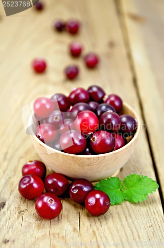 Image of Cranberries in a wooden bowl on the board