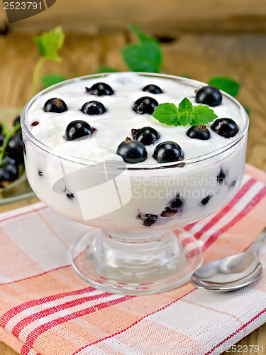 Image of Yogurt is thick with black currants and spoon on the board