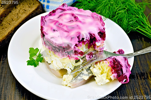 Image of Herring with vegetables in white plate with a fork