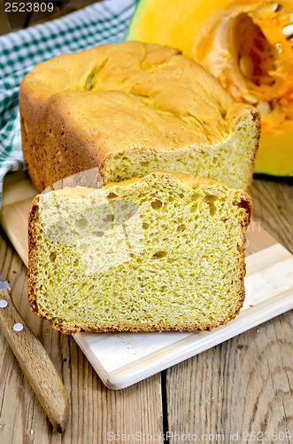 Image of Bread pumpkin on a board with a pumpkin