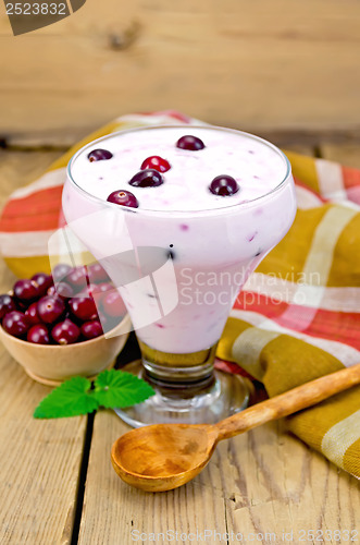 Image of Yogurt thick with cranberries and spoon on the board