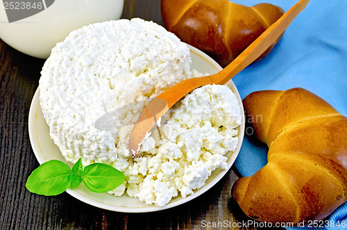 Image of Curd with a wooden spoon and bagel on the board