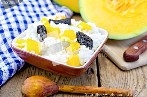 Image of Rice with pumpkin and a wooden spoon on the board