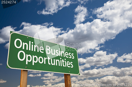 Image of Online Business Opportunities Green Road Sign and Clouds