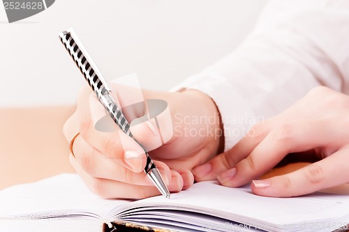 Image of Woman writing in organizer