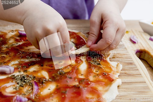 Image of small hands preparing pizza