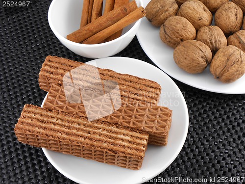 Image of set of cake, walnut and cinnamon on white plate