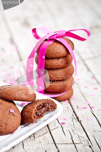 Image of plate of fresh chocolate cookies with pink ribbon and confetti 