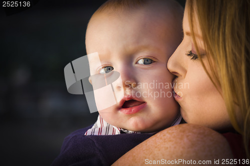 Image of Adorable Red Head Infant Boy is Kissed By His Mother