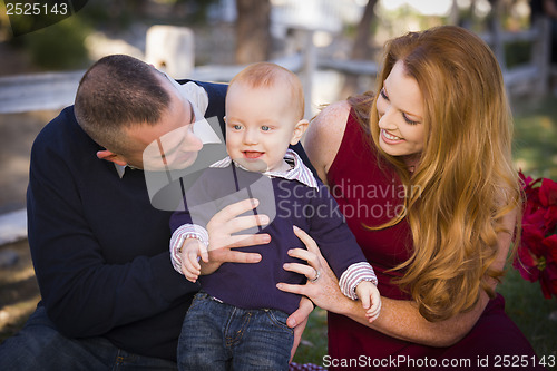 Image of Infant Boy and Young Military Parents Play in the Park