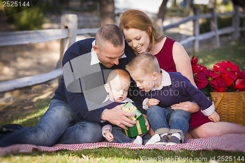 Image of Small Young Family Opening Christmas Gifts in the Park