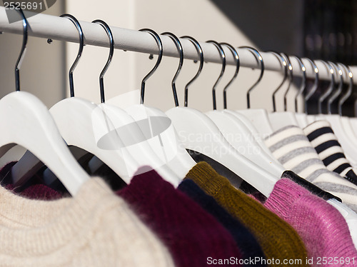 Image of Clothes hang on a shelf in a store