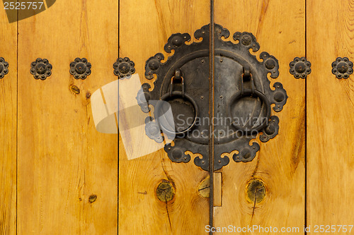 Image of Traditional metallic door knob with wooden door