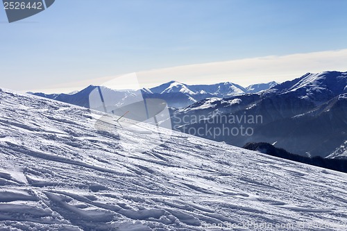 Image of Ski slope with trace of ski, snowboards and mountains in haze