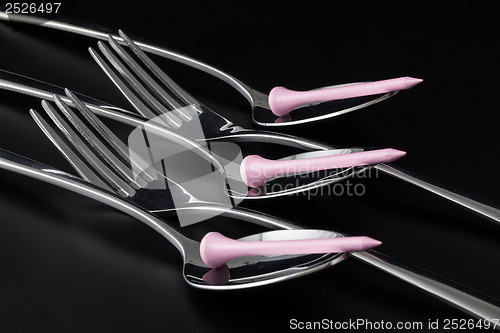 Image of Forks and spoons on a black table