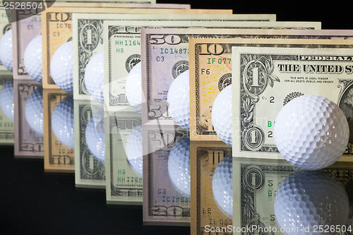 Image of Golf balls and US dollars banknotes